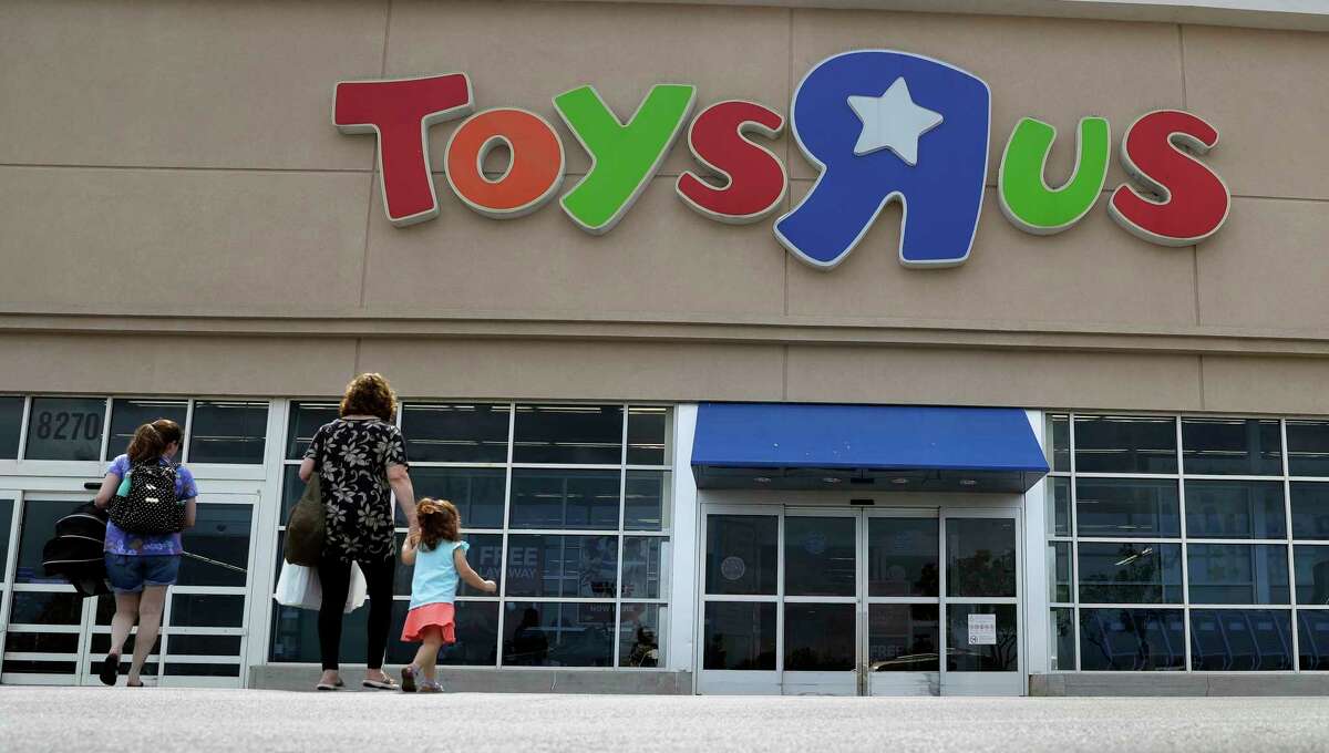 FILE - In this Sept. 19, 2017, file photo, shoppers walk into a Toys R Us store, in San Antonio. Toys R Us says it will be closing some U.S. stores and converting others to cobranded locations as it continues to deal with its financial restructuring following its bankruptcy filing. (AP Photo/Eric Gay, File)