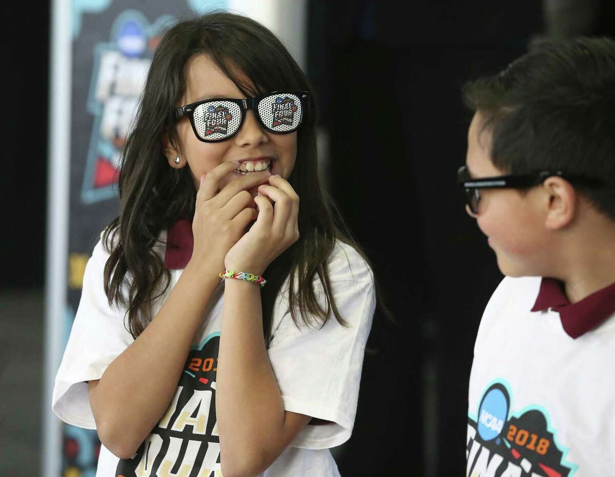 Alina Vega giggles as she and Brian Ybarra put on Final Four glasses after leaders gather at Higgs Carter & King School gymnasium to announce key details for the NCAA Final Four Legacy Project on January 24, 2018.