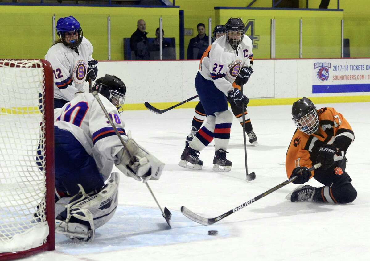 SWS goalie defends the shot of Ridgefield Julia Zangre (17) in a FCIAC girls ice hockey game at Terry Connors Ice Rink in Stamford, Conn. on Wednesday, Jan. 24, 2018.