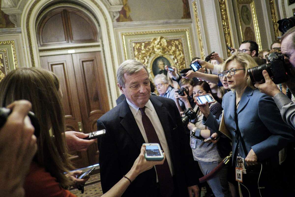 Surrounded by members of the media, Illinois Sen. Dick Durbin leaves a meeting of Democrats after the Senate voted overwhelmingly on Monday to end the government shutdown, with Democrats joining Republicans on a short-term spending package. Readers comment on the three-day shutdown.
