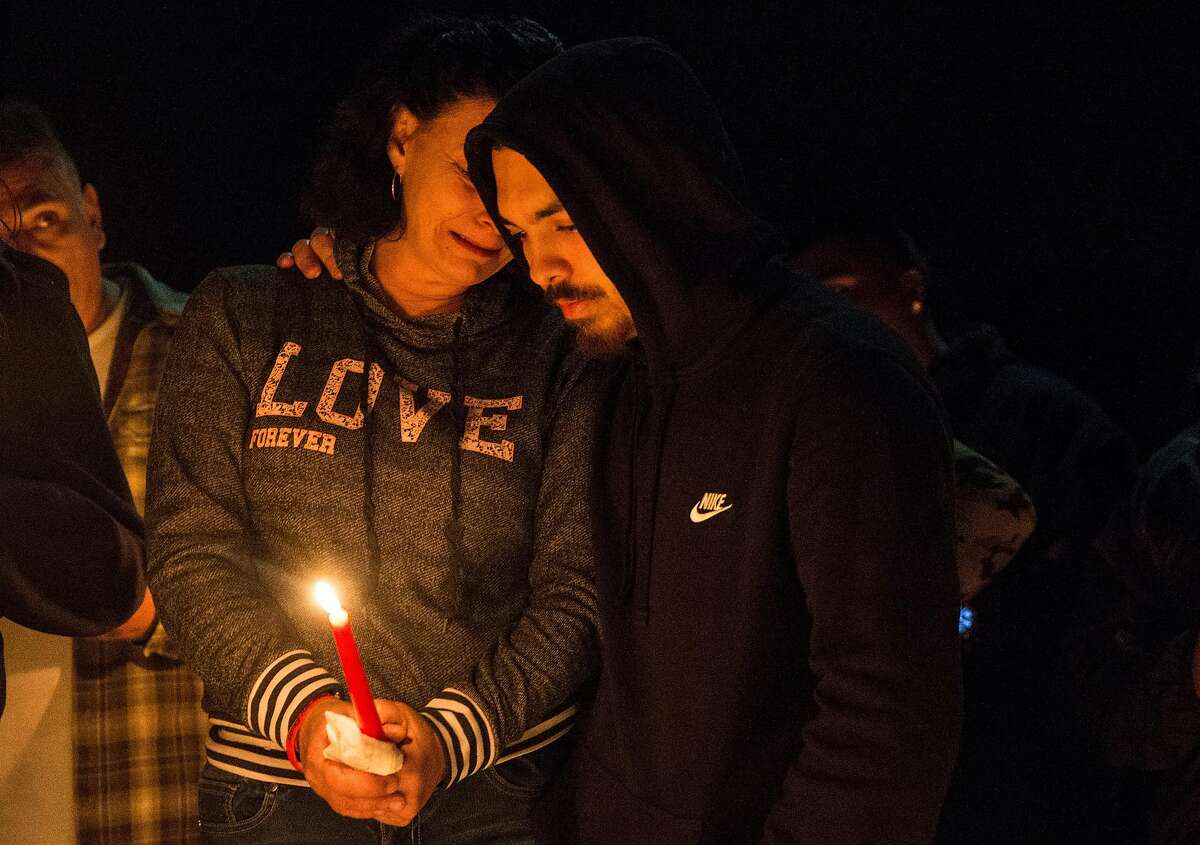 Dante Ramos holds his mother, Annice Evans, as she cries during a candlelight vigil for her son, Angel Ramos, who was shot and killed by Vallejo Police, on the one year anniversary of his death Tuesday, Jan. 23, 2018 in Vallejo, Calif.