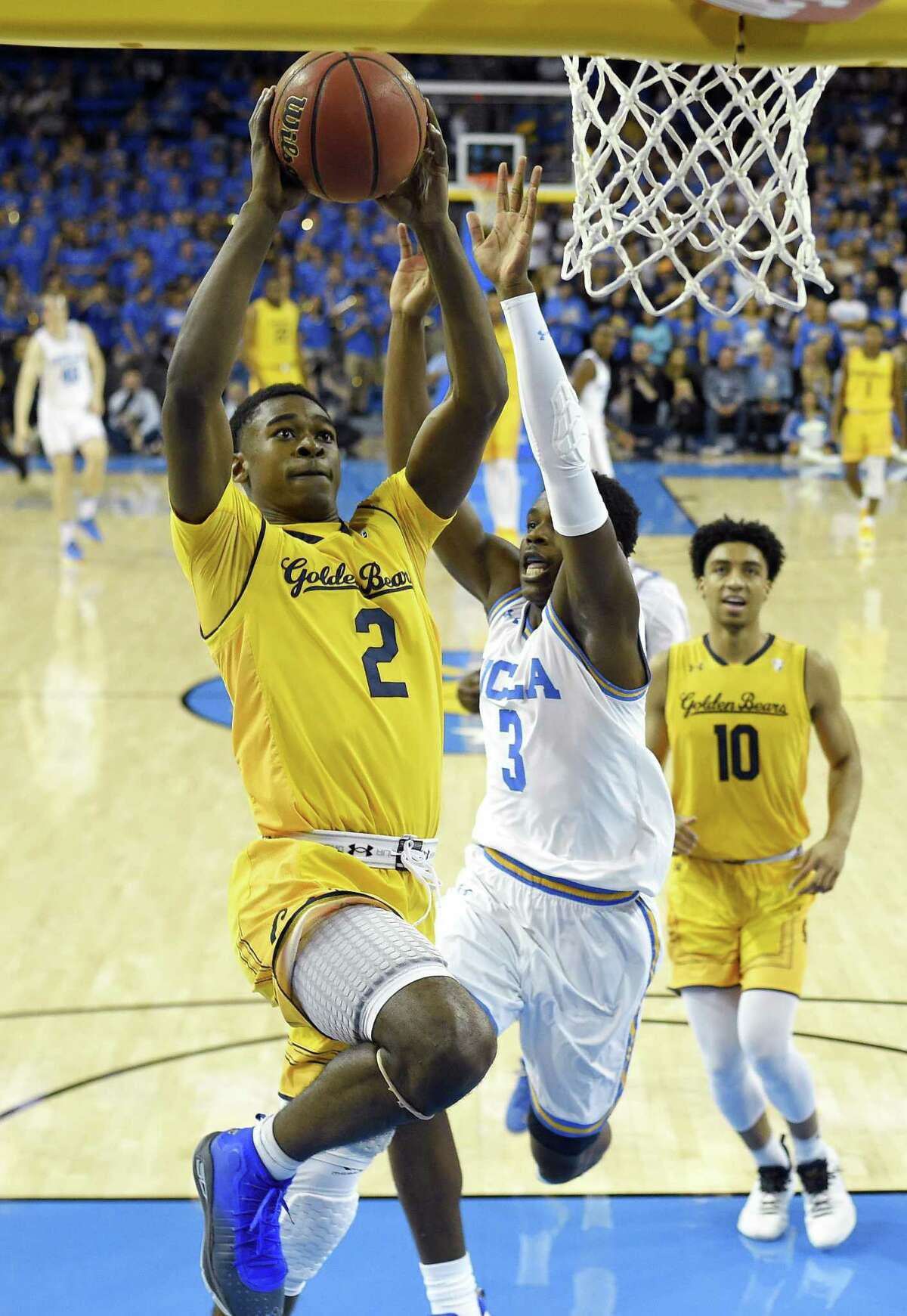 California guard Juhwan Harris-Dyson, left, shoots as UCLA guard Aaron Holiday, center, defends and California forward Justice Sueing watches during the first half of an NCAA college basketball game Thursday, Jan. 25, 2018, in Los Angeles. (AP Photo/Mark J. Terrill)