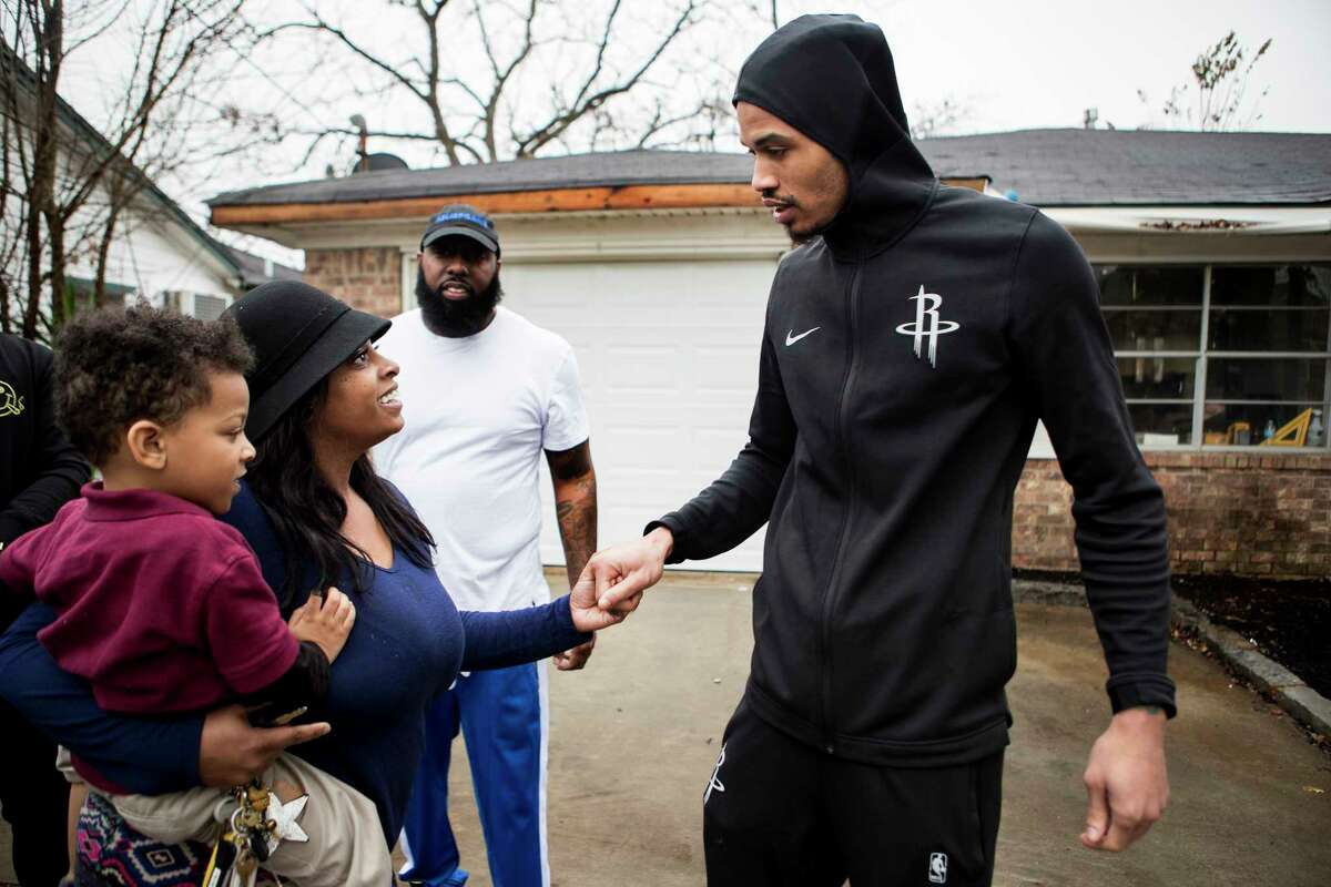 Tia Joseph and her son, Corey Drouselle, greet Gerald Green outside her home. Green, Trae tha Truth and Justin "DJ Mr. Rogers" Rogers are helping rebuild the home.﻿