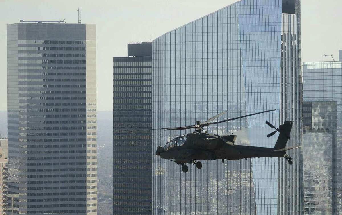 A Texas National Guard Apache attack helicopter based at Ellington Field flies by the Houston skyline during a training mission on Wednesday, Jan. 24, 2018.