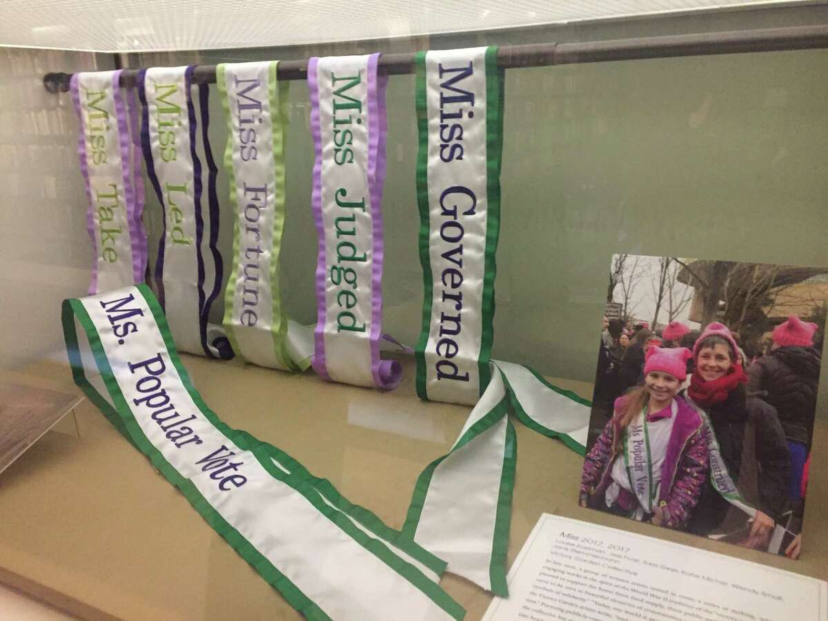 A display case of sashes from a recent women’s rally.