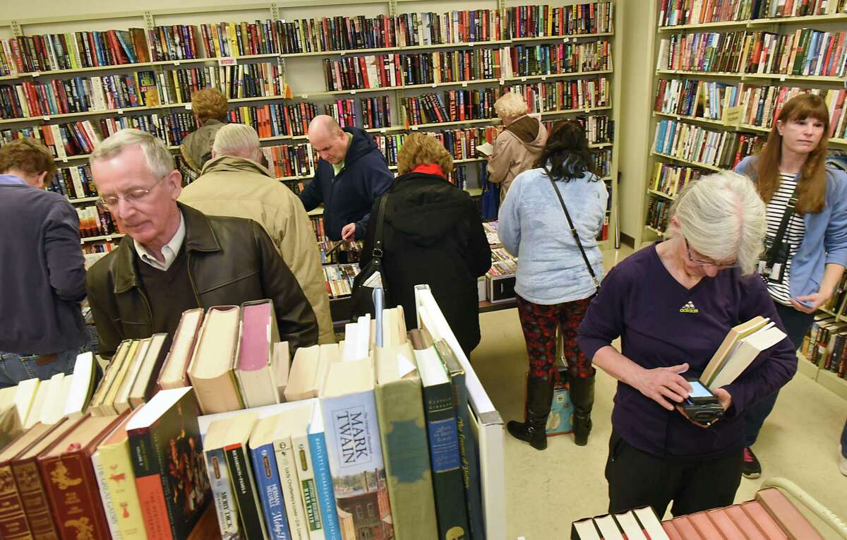 People browse for books at the winter used book sale at the Clifton Park-Halfmoon Library in 2018. Voters have overwhelmingly approved the library's 2022 budget. (Times Union file)
