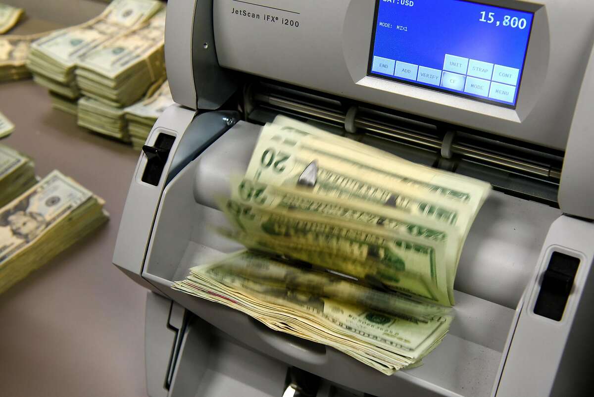 A cashier runs a marijuana business owner's cash tax payment through a money counter at the California Department of Tax and Fee Administration in Oakland, CA, on Monday November 27, 2017.