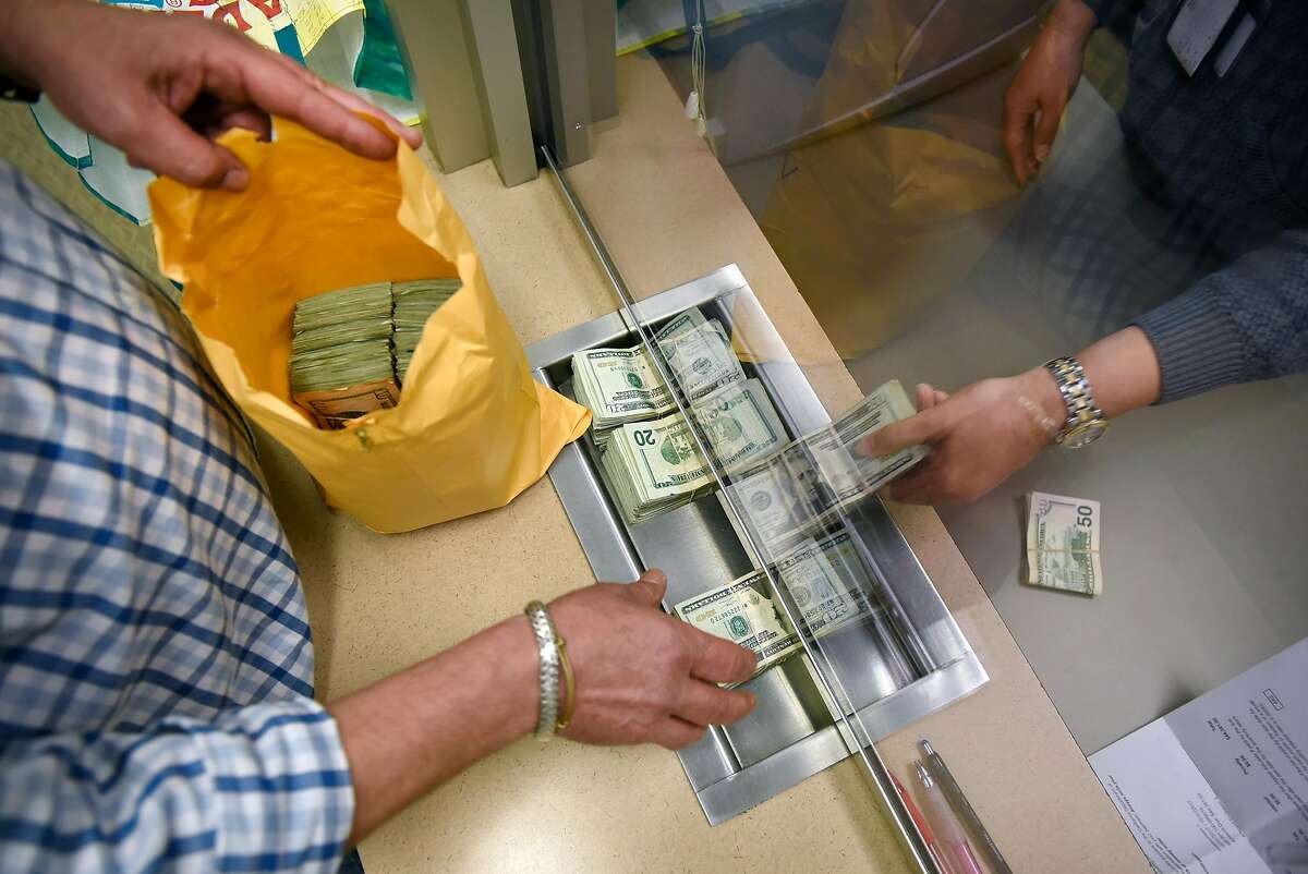 A marijuana business owner pays his taxes in cash at the California Department of Tax and Fee Administration in Oakland, CA, on Monday November 27, 2017.