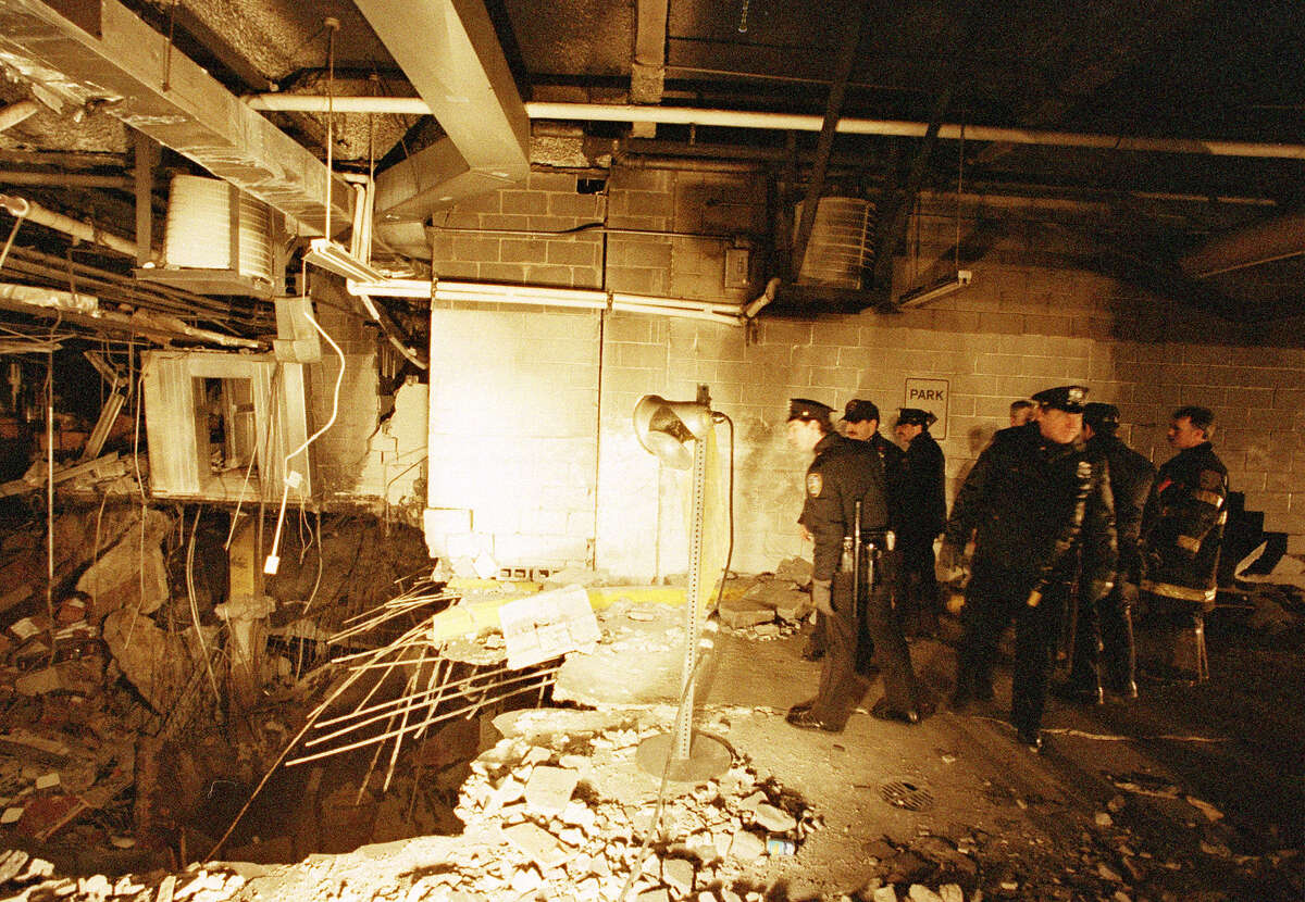 FILE - In this file photo of Feb. 27, 1993, police and firefighters inspect the bomb creator inside an underground parking garage of New York's World Trade Center the day after an explosion tore through it. The National September 11 Memorial & Museum on Friday, Jan. 26, 2018 announced the opening of a special installation to commemorate the 25th anniversary of the 1993 truck bombing of the World Trade Center. (AP Photo/Richard Drew, File)