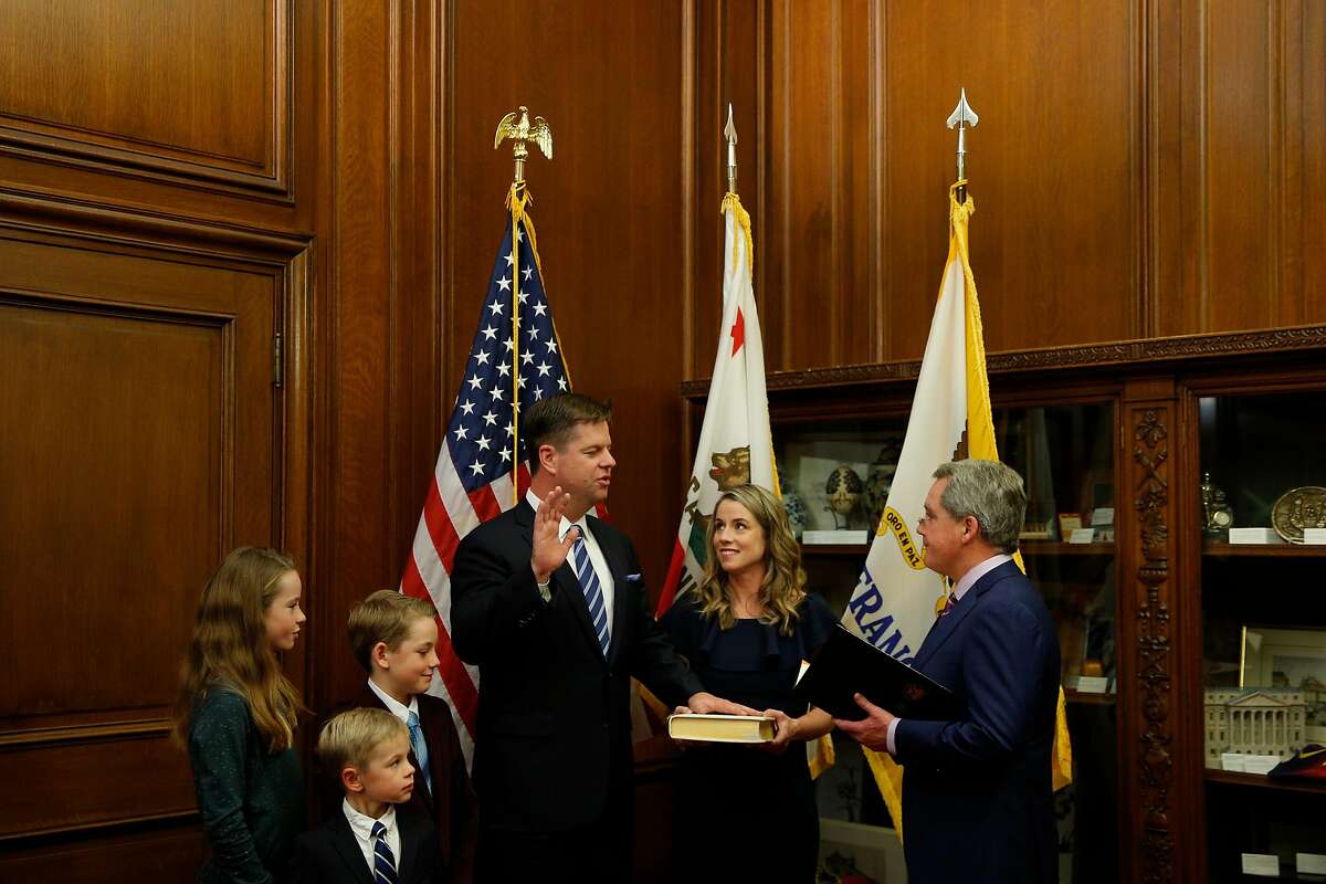 Mark Farrell is sworn in as interim mayor by City Attorney Dennis Herrera, as he stands with his wife and children at City Hall after being voted interim mayor by the board of supervisors, Tuesday, Jan. 23, 2018, in San Francisco, Calif.