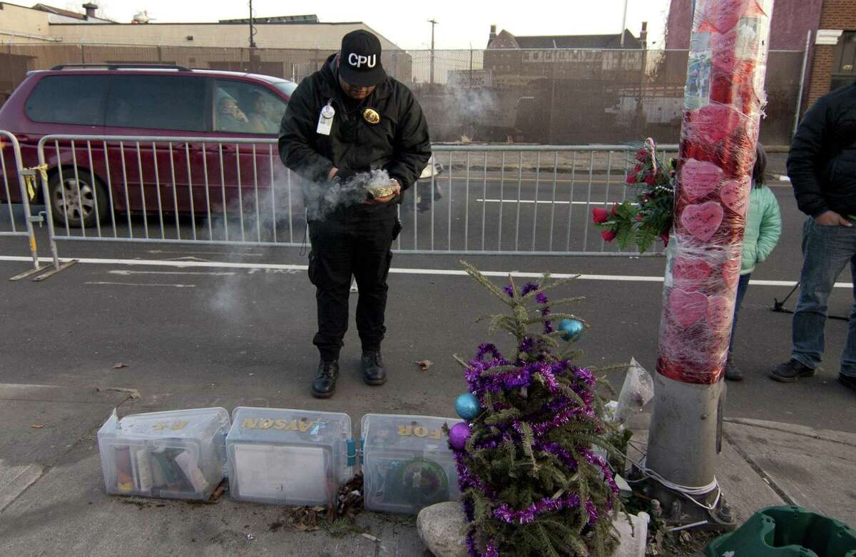 Angel Martinez, with Copwatch Patrol Unit, burns sage for a purification ceremony before about 350 family, friends and activist organizations gather at the memorial for Jayson Negron on Fairfield Avenue in Bridgeport, Conn., on Friday, Jan. 26, 2018. There was a heavy police presence at the memorial and as the protestors marched later to city hall annex nearby. Negron was shot and killed by Bridgeport Police Officer James Boulay during an incident on May 9, 2017. Officer Boulay and the Bridgeport Police Department were cleared in the investigation earlier in the day.