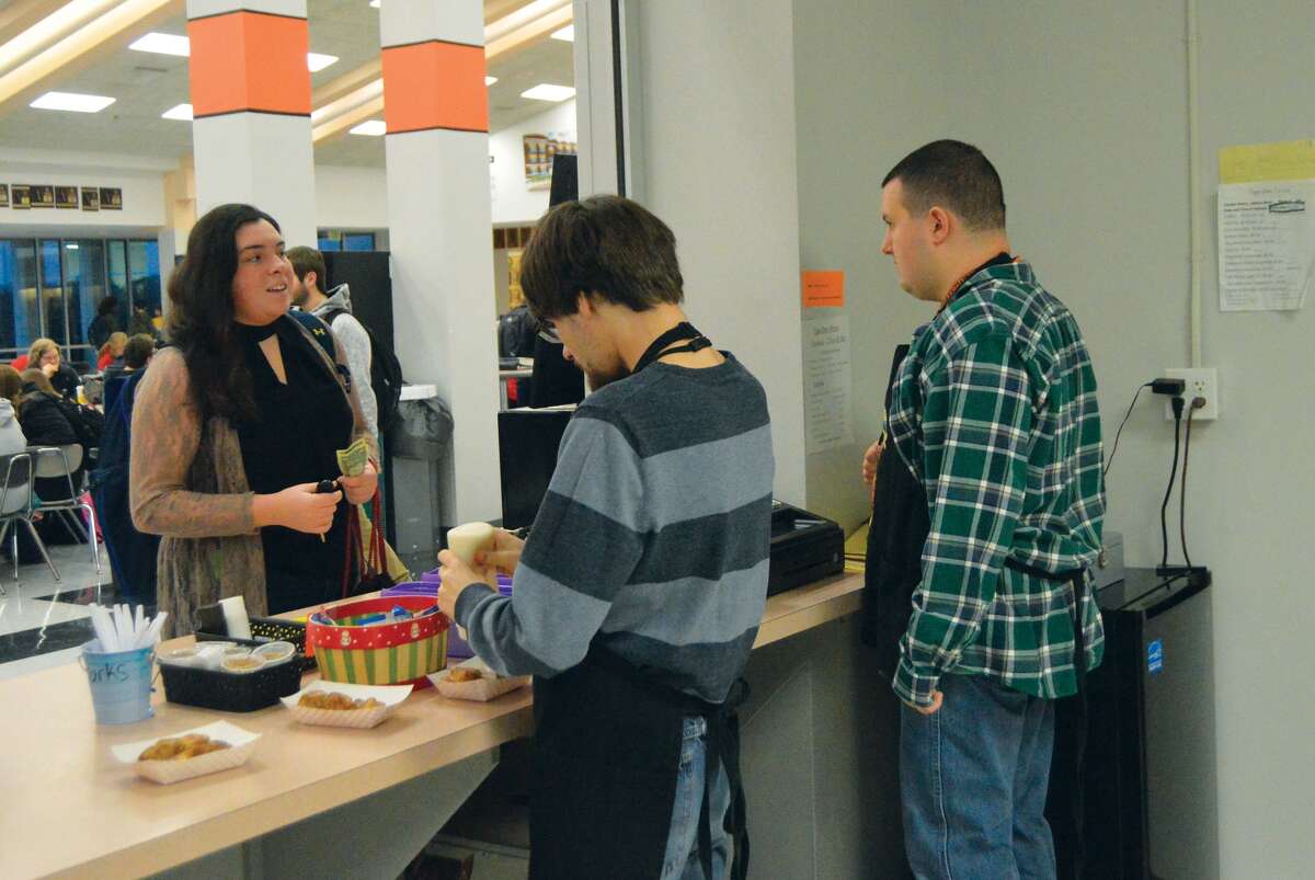 Edwardsville High School student Sydney Sahuri makes a purchase at the Tiger Den before the start of school. FLS students Caleb Byrd, left, and Cameron Ellsworth are behind the counter.