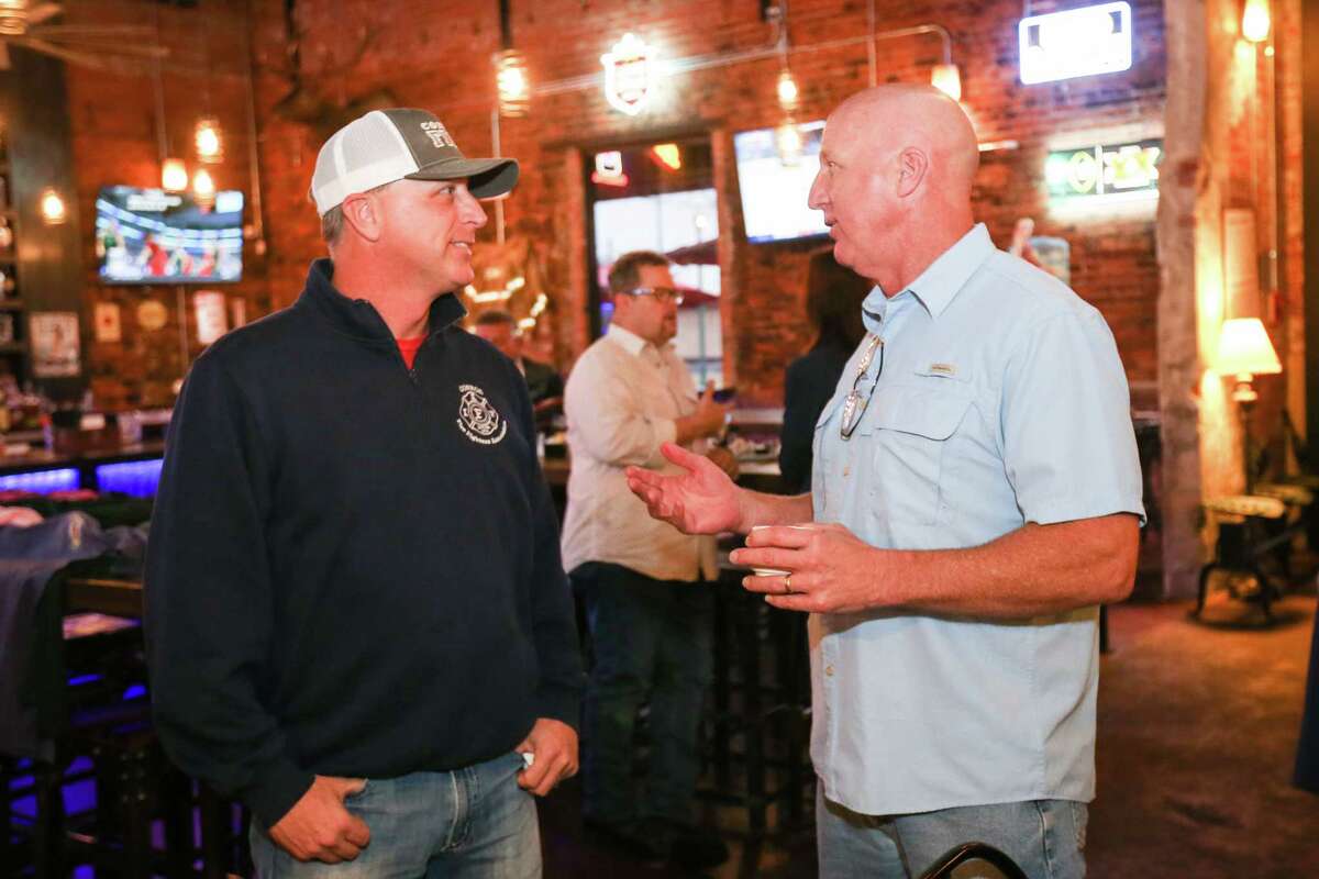 Lloyd Sandefer, Conroe Professional Firefighters Association President, left, and Conroe Fire Chief Ken Kreger, right, chat during a pancake breakfast and book signing fundraiser for PTSD awareness on Saturday at Pacific Yard House in Conroe.