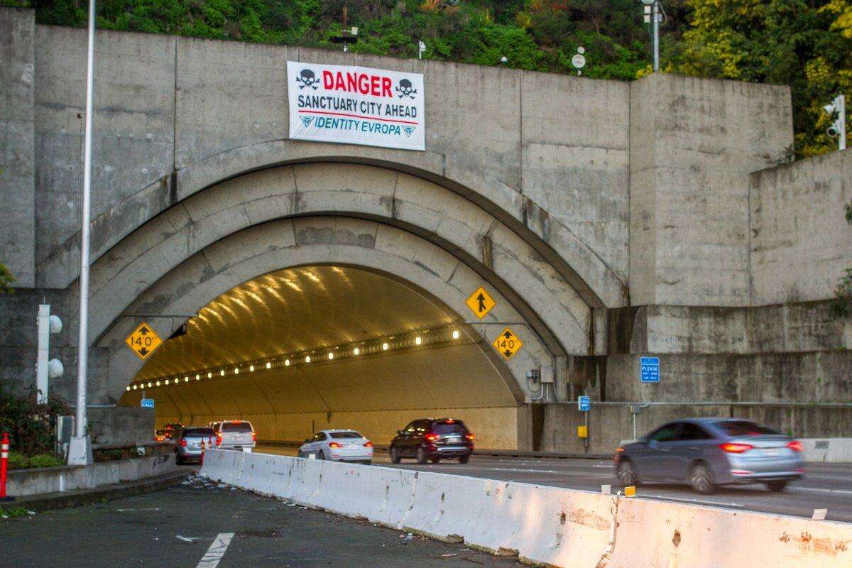 A sign mocking San Francisco’s sanctuary city policy was hung early Sunday over the Yerba Buena Island Tunnel in San Francisco.