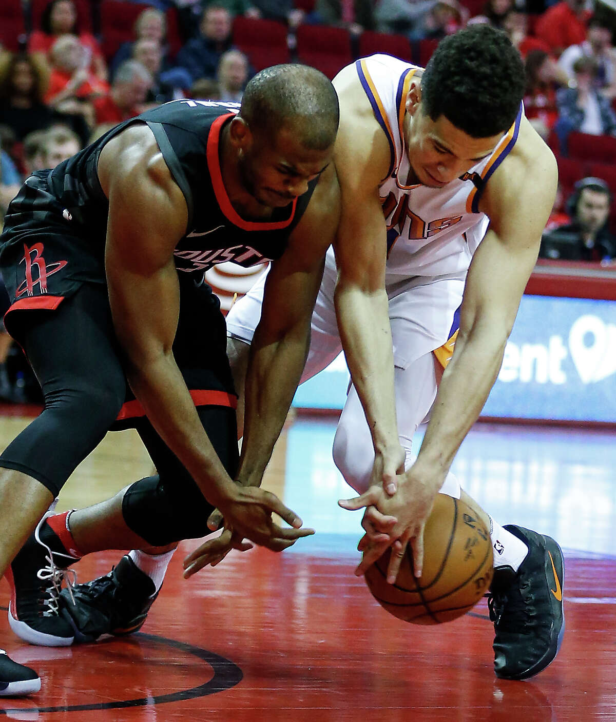 Houston Rockets guard Chris Paul (3) and Phoenix Suns guard Devin Booker (1) go after a loose ball during the first quarter of an NBA basketball game at Toyota Center on Sunday, Jan. 28, 2018, in Houston. ( Brett Coomer / Houston Chronicle )