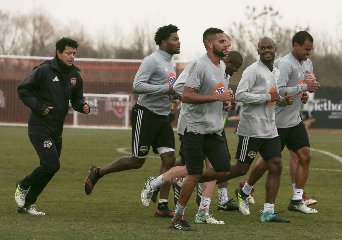 Dynamo head coach Wilmer Cabrera runs with players after an open practice day for fans at Houston Sports Park on Saturday, Jan. 27, 2018, in Houston.