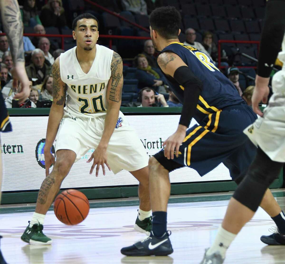Siena point guard Roman Penn dribbles the ball between his legs as Canisius point guard Isaiah Reese watches during an MAAC conference game on Sunday, Jan. 7, 2018 at the Times Union Center in Albany, N.Y. Siena held on for a 65-62 victory against Canisius. (Jenn March/Special to the Times Union)