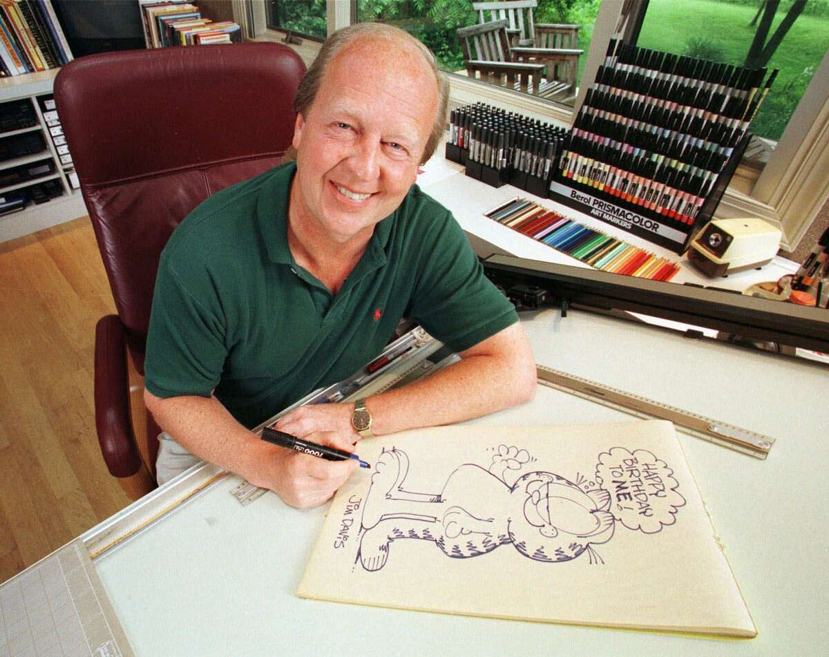 “Garfield” creator Jim Davis,drawing the cartoon character in his Muncie, Ind., office in 1998, file photo.