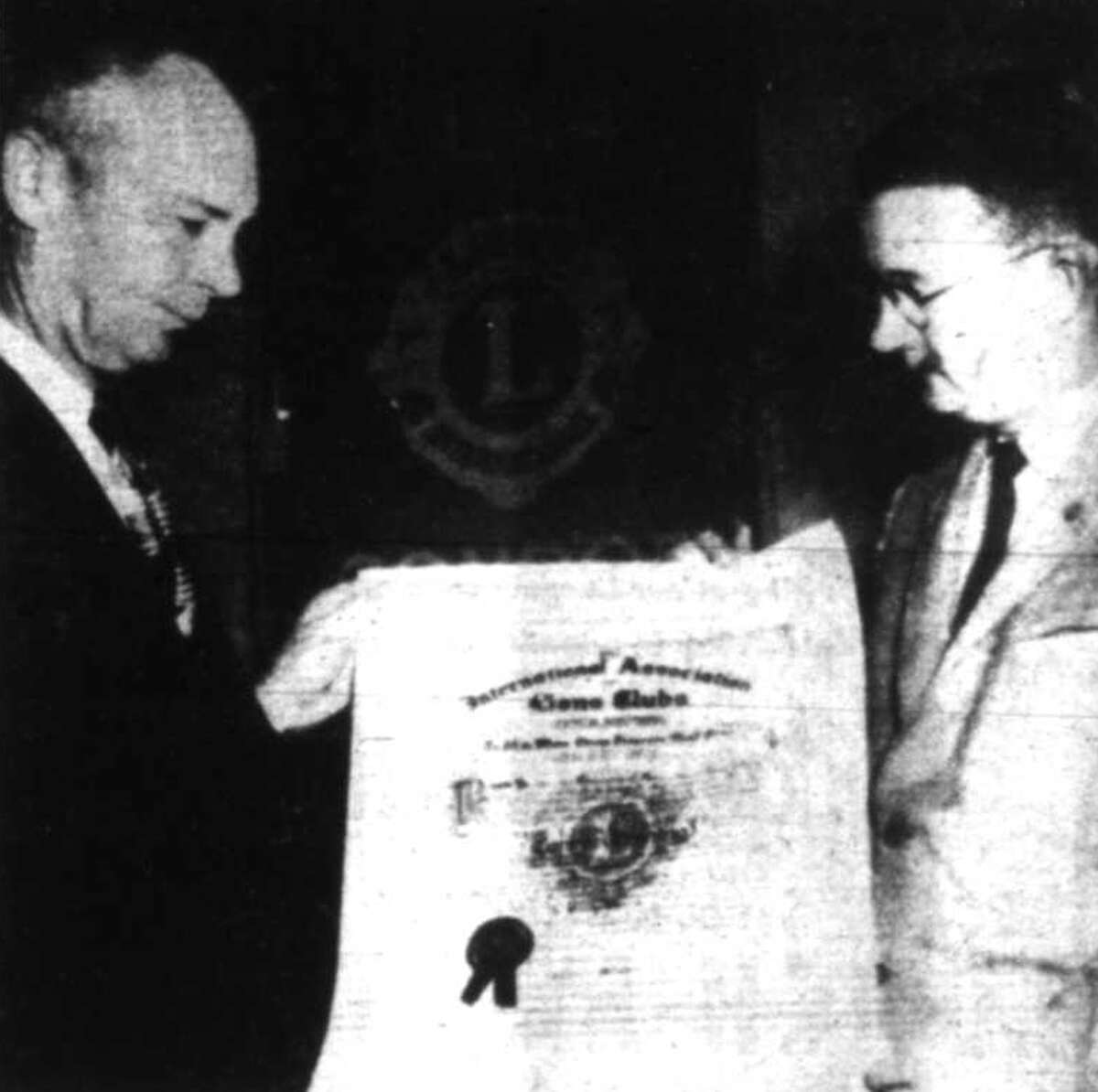 Frank Zachry, left, first president of the Conroe Evening Lions Club, is presented a charter for the group by Robert Lundy, Lions Club International District Governor on Jan. 30, 1958.