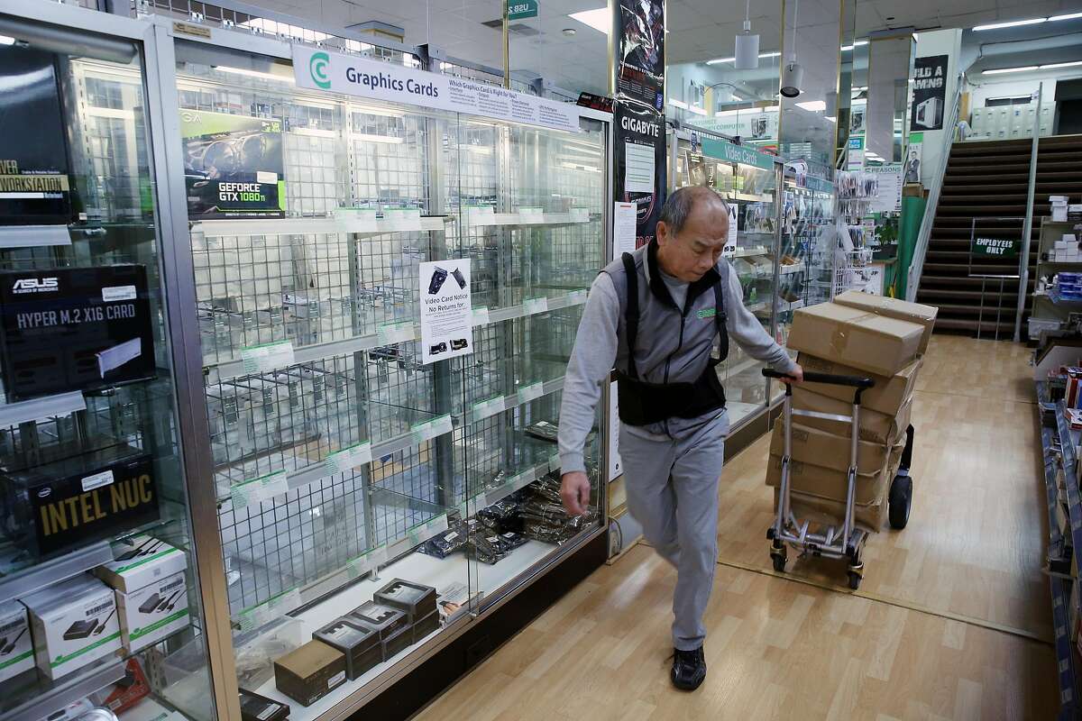 Sam Duong moves boxes to stock the store at Central Computers, Thursday, Jan. 25, 2018, in San Francisco, Calif. Cryptocurrency miners are buying out all the high-end graphics processor units they can find, which is driving the prices up and causing supply shortages at stores like Central Computers. A single unit was on display, an EVGA GeForce GTX 1080 Ti SC for $1,059.95.