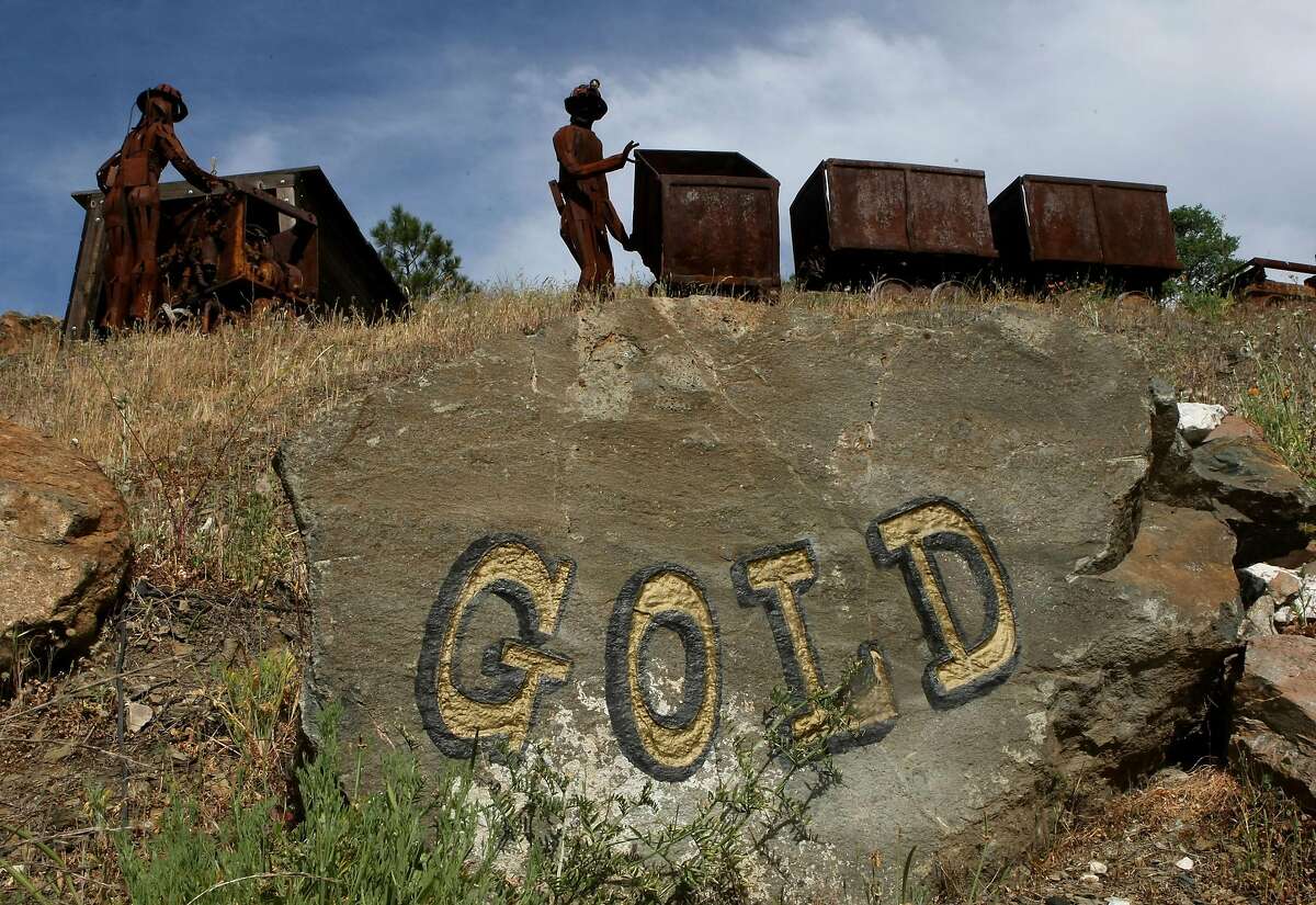 描绘矿工的人像站在萨特溪(阿马多尔县)萨特金矿外的旧矿车旁。对于那些想要一夜暴富的人来说，光是到达加州就可能是危险的，尤其是那些试图穿越巴拿马来到这里的人。