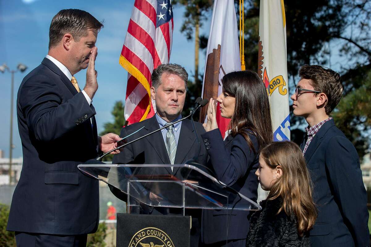 Catherine Stefani is sworn in by interim Mayor Mark Farrell, left, as Stefani stands with her husband and children at the Marina Branch Library Plaza, Tuesday, Jan. 30, 2018, in San Francisco, Calif. County Clerk Catherine Stefani was sworn in as District 2 supervisor, replacing interim mayor Mark Farrell.