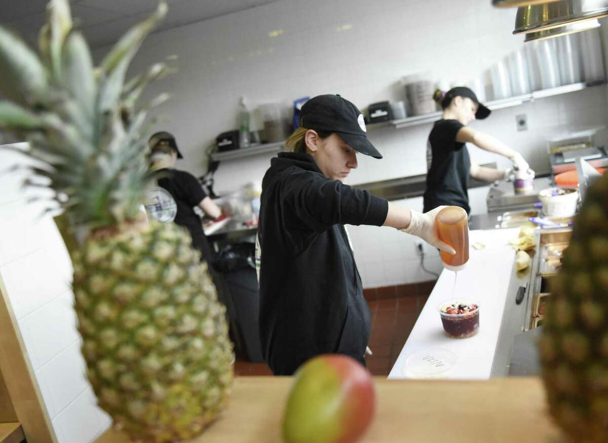 Samantha Simmonds drizzles honey on an acai bowl at SoBol in the Cos Cob section of Greenwich, Conn. Tuesday, Jan. 30, 2018. SoBol serves bowls and smoothies using the South American super fruit acai. The franchise has more than a dozen locations, mostly on Long Island, but the Cos Cob shop is the first in Connecticut.