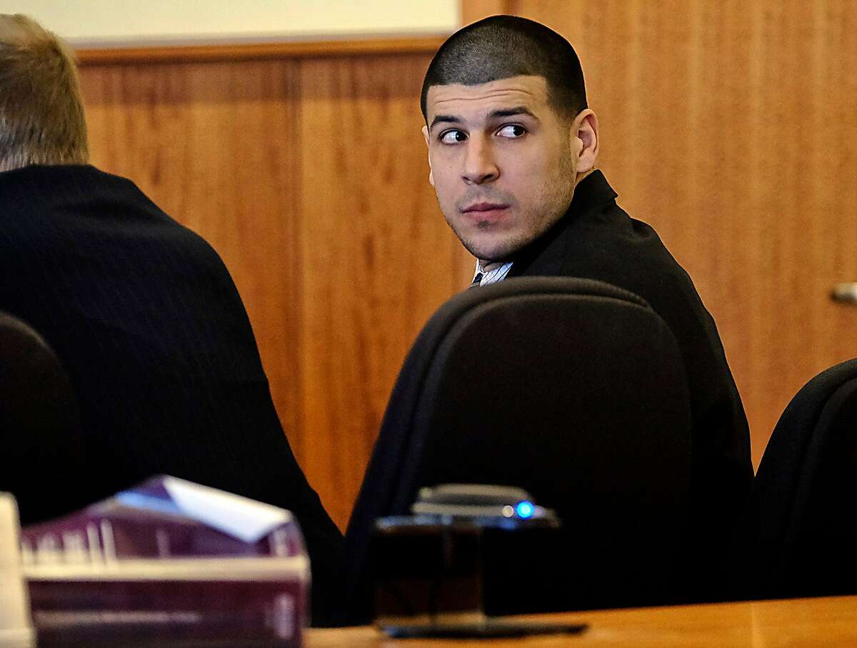 Aaron Hernandez, a former New England Patriots NFL football player, looks back towards the gallery during the pre-trial motion hearing in the Superior Court in Fall River, Mass., Friday, Dec. 12, 2014. Judge Susan Garsh says prosecutors in the murder case against Hernandez may not tell jurors about two other killings with which the he is charged. Hernandez has pleaded not guilty to murder in the 2013 killing of Odin Lloyd, a semi-professional football player who was dating the sister of Hernandez's fiancee. He has also pleaded not guilty to the fatal shootings of two men in 2012 after an encounter at a Boston nightclub. (AP Photo/The Boston Globe, Robert E. Klein, Pool)