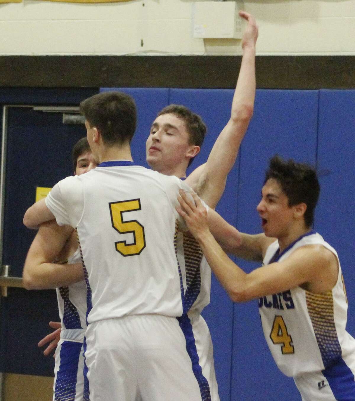 Brookfield High School boys basketball players celebrate with Cam Gleichauf, center, after Gleichauf's last-second shot lifted the Bobcats to an overtime victory over Immaculate at Brookfield High School Jan. 30, 2018.