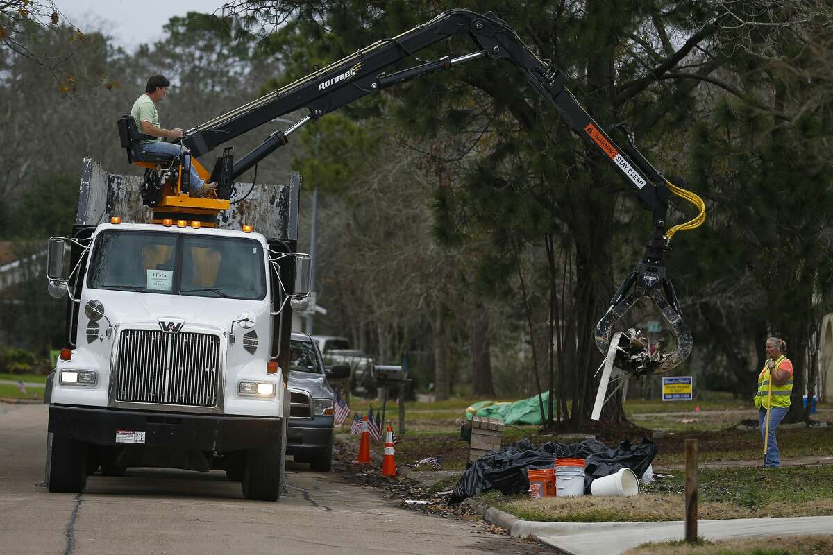 A FEMA disaster recovery vehicle picks up flood debris from a home in the Forest Bend neighborhood Thursday, Jan. 11, 2018 in Friendswood. The city of Friendswood has reverted from 2007 flood maps to 1999 maps to allow homeowners that were flooded during Hurricane Harvey to rebuild without mandating expensive home elevation requirements. ( Michael Ciaglo / Houston Chronicle)