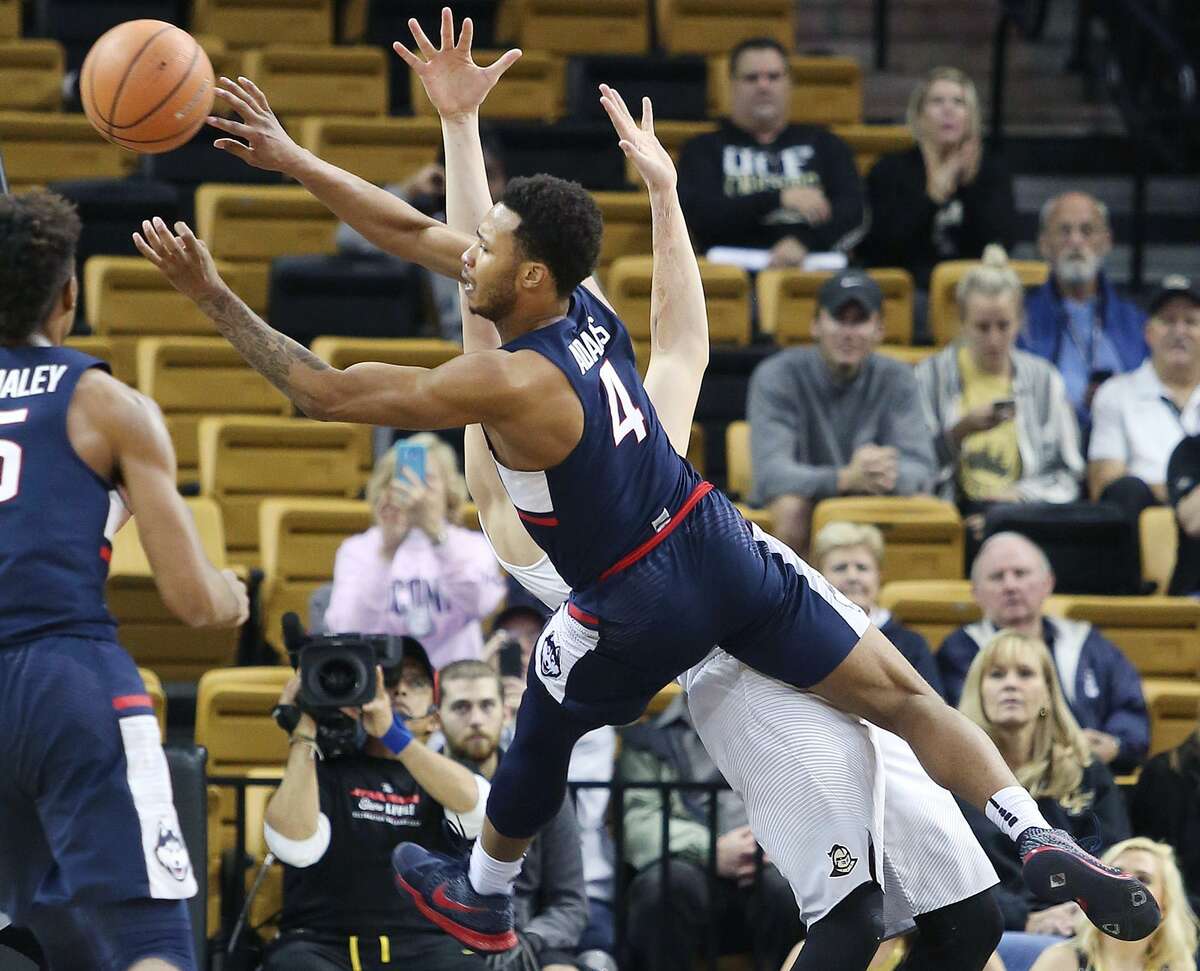UConn guard Jalen Adams (4) leaps into UCF forward Rokas Ulvydas during the first half of their game Wednesday night at CFE Arena in Orlando, Fla.