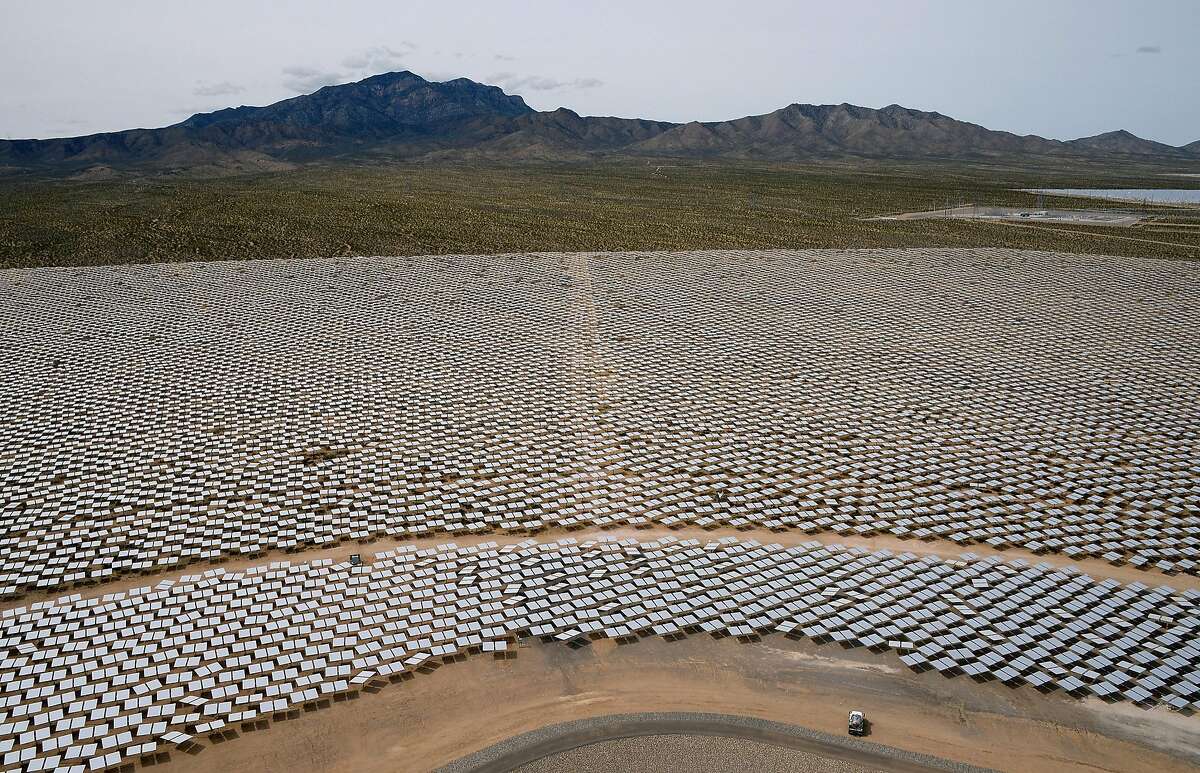 Heliostats at the Ivanpah Solar Electric Generating System are seen from above in front of the Clark Mountain Range on March 3, 2014 in the Mojave Desert in California near Primm, Nevada. The largest solar thermal power-tower system in the world, owned by NRG Energy, Google and BrightSource Energy, opened recently in the Ivanpah Dry Lake and uses 347,000 computer-controlled mirrors to focus sunlight onto boilers on top of three 459-foot towers, where water is heated to produce steam to power turbines providing power to more than 140,000 California homes. (Photo by Ethan Miller/Getty Images)
