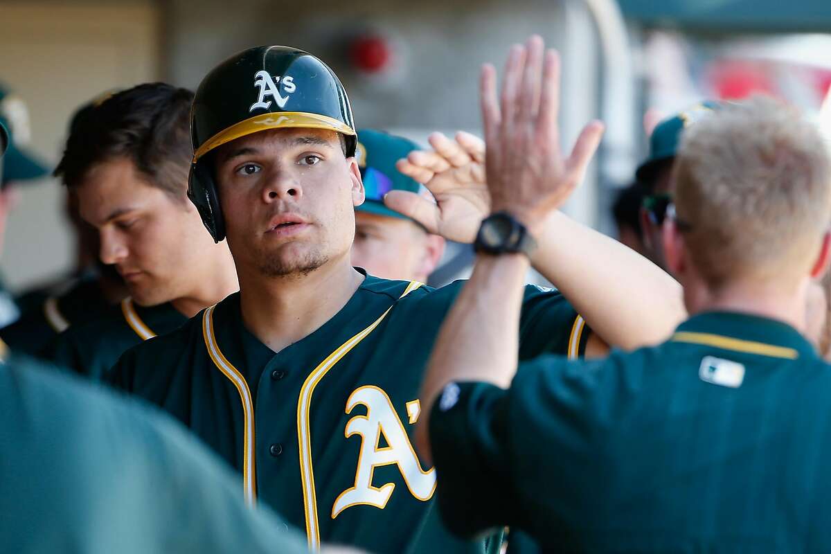 SCOTTSDALE, AZ - MARCH 04: Bruce Maxwell #63 of the Oakland Athletics high fives teammates in the dugout after scoring a second inning run against the Arizona Diamondbacks during the spring training game at Salt River Fields at Talking Stick on March 4, 2016 in Scottsdale, Arizona. (Photo by Christian Petersen/Getty Images)
