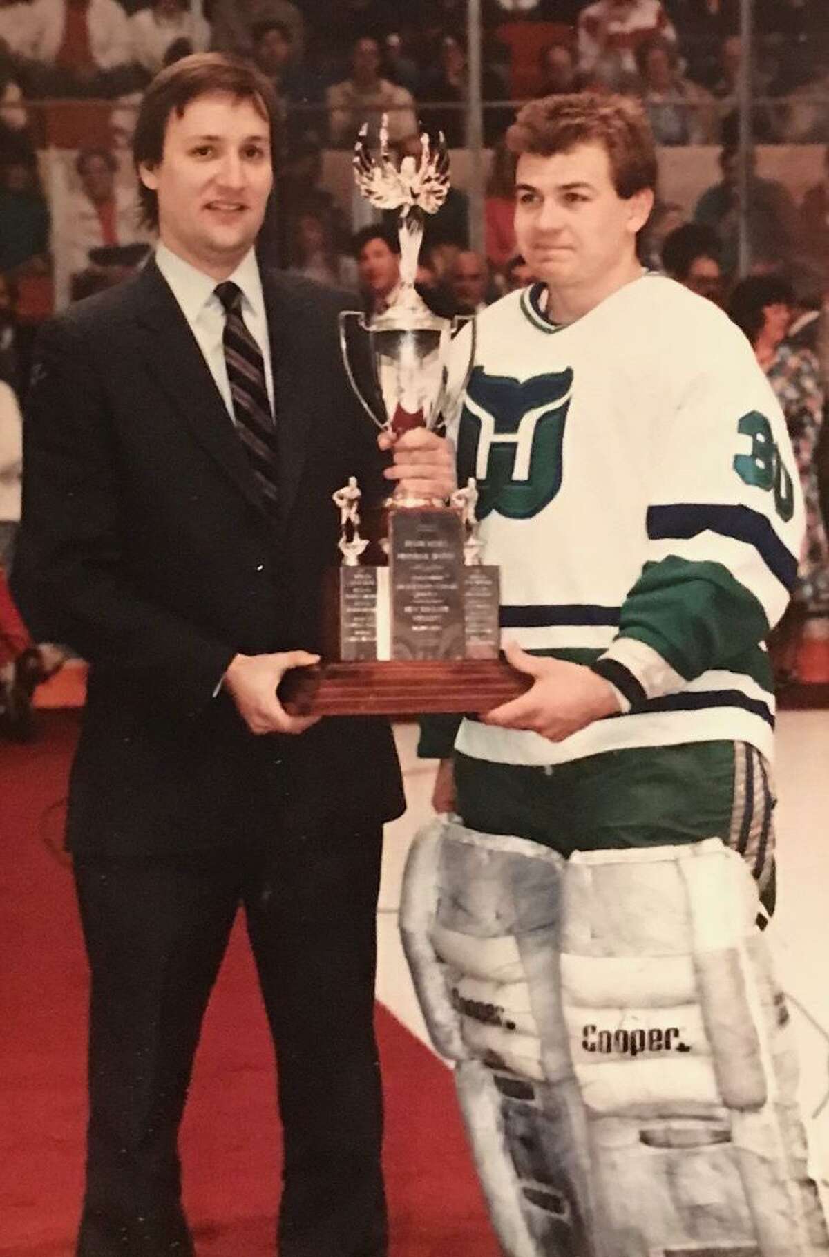 Columnist Jeff Jacobs presents Hartford Whalers goalie Peter Sidorkiewicz with an award in 1989.