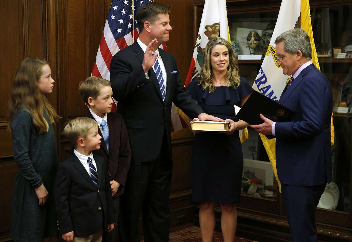 Mark Farrell is sworn in as interim mayor of San Francisco by City Attorney Dennis Herrera, as he stands with his wife and children at City Hall after being voted interim mayor by the board of supervisors, Tuesday, Jan. 23, 2018, in San Francisco, Calif. (Santiago Mejia/San Francisco Chronicle via AP)