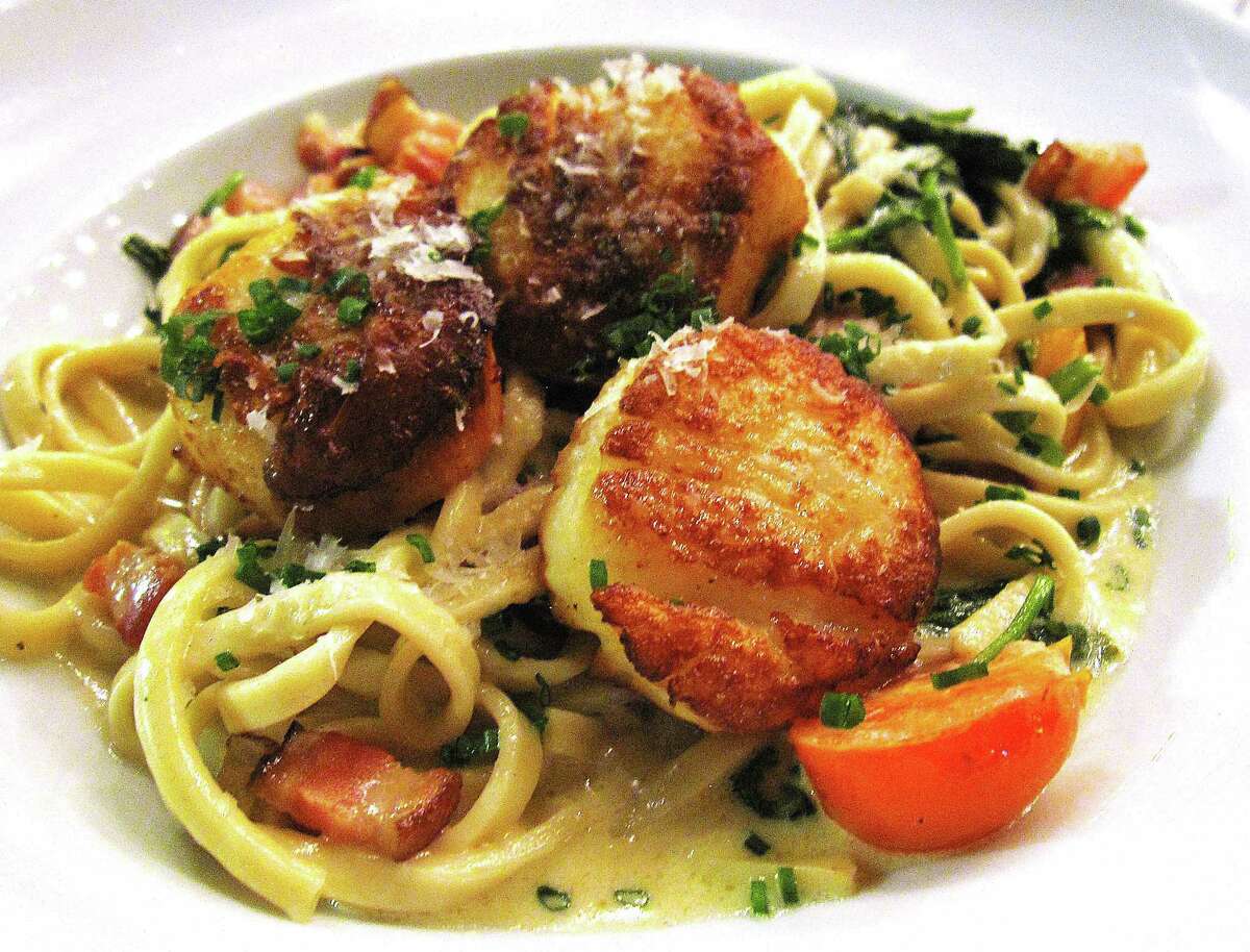 Seared scallops with linguine, spinach, lardons, cherry tomatoes and Brussels sprouts from Il Sogno.