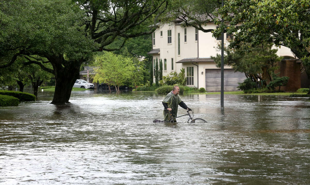 A Houston man makes his way along an inundated portion of Chimney Rock ﻿after Brays Bayou flooded the Meyerland area in April 2016.