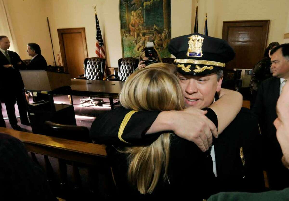 Newly promoted police chief Christoper Cole receives a hug from his daughter Andrea Cole after a news conference naming him the new chief at City Hall in Saratoga Springs on Dec. 4. (Michael P. Farrell/Albany Times Union)