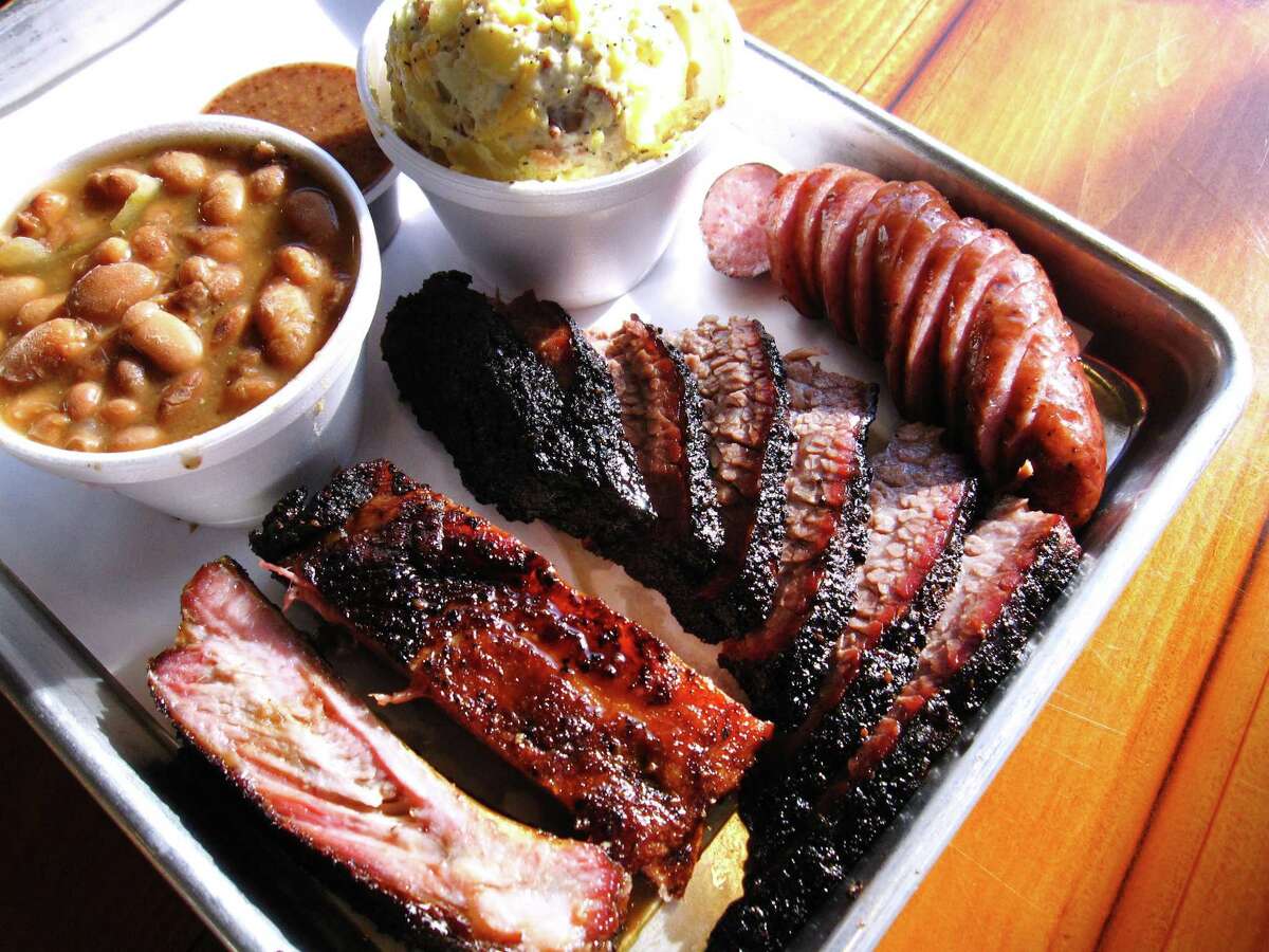 A platter of pork ribs, brisket, sausage, loaded baked potato salad and beans from Smoke Shack BBQ.