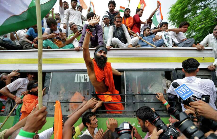 Indian yoga guru Baba Ramdev waves out of the window of a bus after he was detained with his supporters by policemen in New Delhi in 2012.&nbsp;The New Indian Express reported Sunday that the prominent yogi will deliver the inaugural address of the 7th annual Translational Cancer Research Conference, which starts Thursday in India.&nbsp; Photo: Saurabh Das, Associated Press / AP