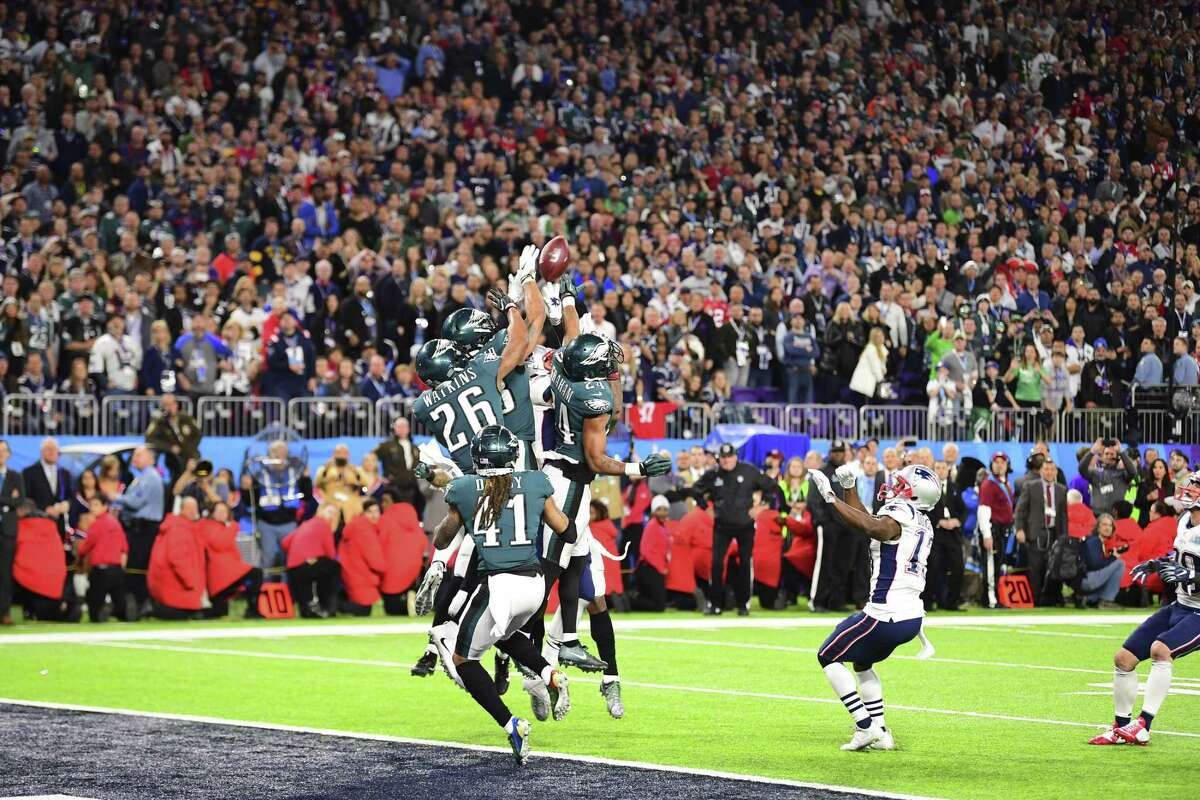 Players jump for the final throw by New England Patriots quarterback Tom Brady in Super Bowl LII against the Philadelphia Eagles at U.S. Bank Stadium in Minneapolis, Feb. 4, 2018. The Sunday night championship, in which the Philadelphia Eagles toppled the New England Patriots 41-33, attracted an overnight rating of 47.4 on NBC, according to preliminary data from the network, down about 3 percent from last year.