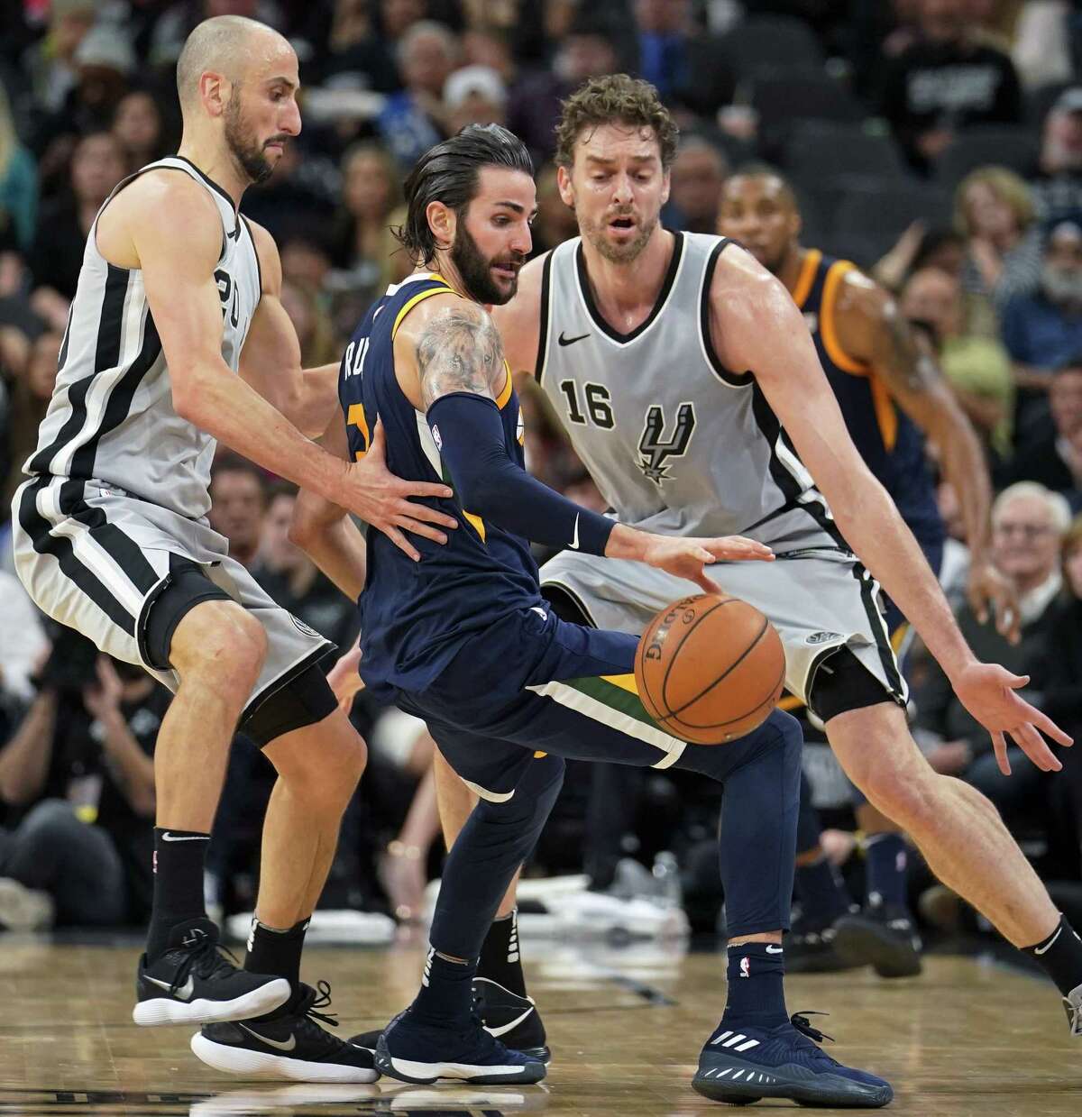 Utah Jazz' Ricky Rubio, center, loses the ball as he is guarded by San Antonio Spurs' Pau Gasol (16) and Manu Ginobili during the first half of an NBA basketball game, Saturday, Feb. 3, 2018, in San Antonio. (AP Photo/Darren Abate)