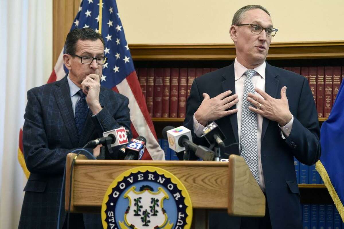 Gov. Dannel P. Malloy, left, listens as Ben Barnes, Secretary of the State of Connecticut Office of Policy and Management, right, speaks about the budget adjustments they are proposing for the 2019 Fiscal Year during a press conference at the state Capitol on Monday.