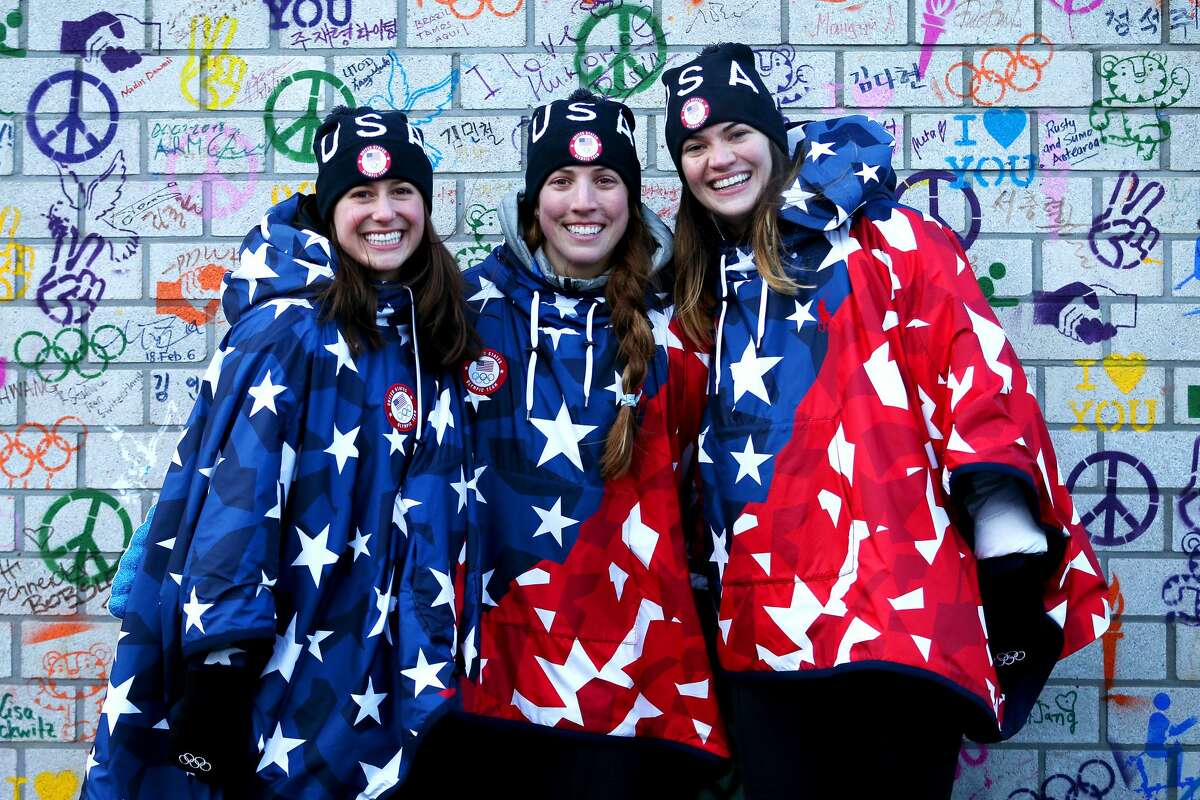 Emily Sweeney, Erin Hamlin and Summer Britcher of the United States pose in front of the Truce Wall after the team's flag raising ceremony ahead of the PyeongChang 2018 Winter Olympic Games.