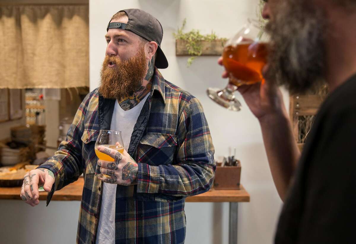 Founder Alex Tweet chats with friends while sipping beer during a special can release at Fieldwork Brewing Company Saturday, Feb. 3, 2018 in Berkeley, Calif.