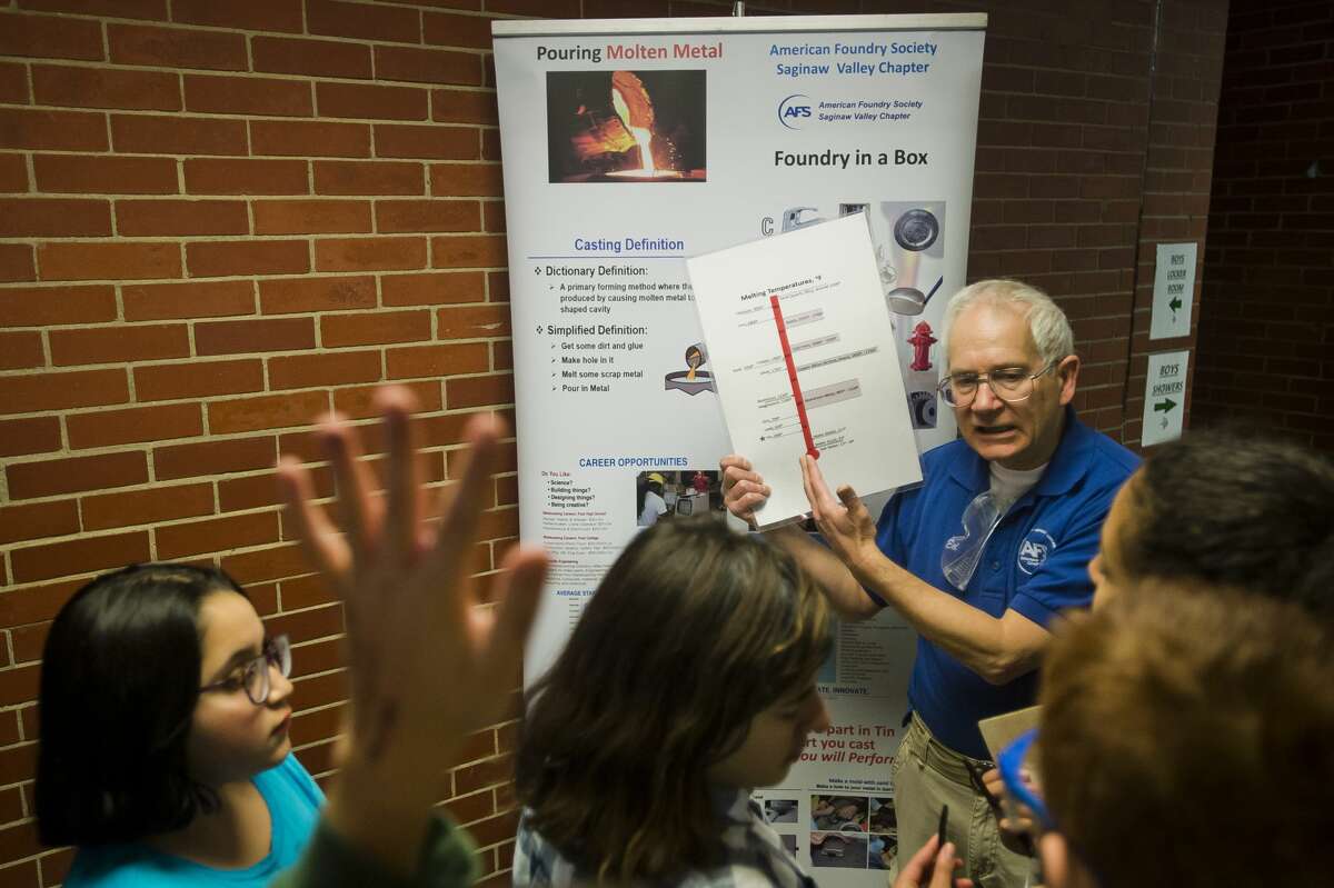 A representative from the American Foundry Society Saginaw Valley Chapter explains how casting metal works during a "foundry in a box" activity during The ROCK after-school program on Tuesday, Feb. 6, 2018 at Northeast Middle School. (Katy Kildee/kkildee@mdn.net)