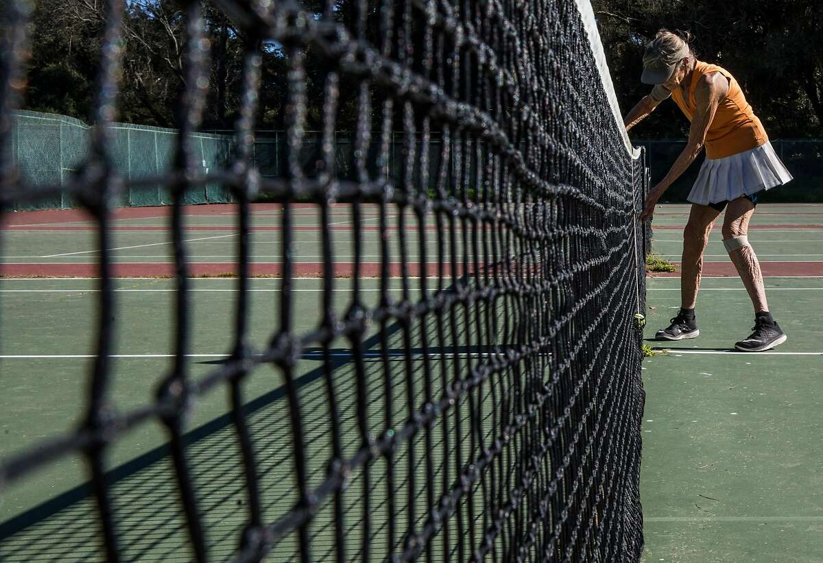 Florence Barich of San Francisco retrieves the ball while playing a match with friends at the Golden Gate Park Tennis Center.