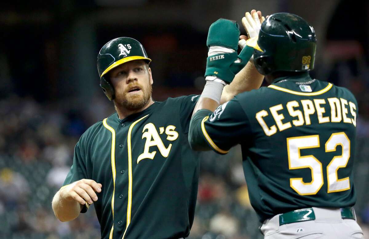 Oakland Athletics' Brandon Moss, left, and Yoenis Cespedes celebrate after scoring on Josh Donaldson's double during the ninth inning of a baseball game against the Houston Astros Tuesday, July 29, 2014, in Houston. The Athletics beat the Astros 7-4. (AP Photo/David J. Phillip)