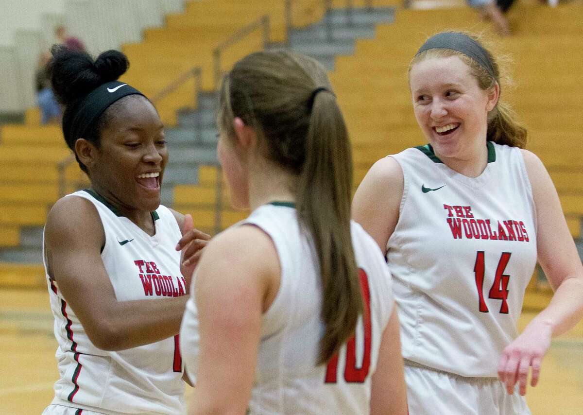 The Woodlands' Joanne Gabriel (1) reacts with Emma Warnsman (14) and Kate Frank (10) after the Lady Highlanders defeated Conroe 44-38 to earn the fourth and final playoff spot from District 12-6A on Tuesday, Feb. 6, 2018, in The Woodlands.