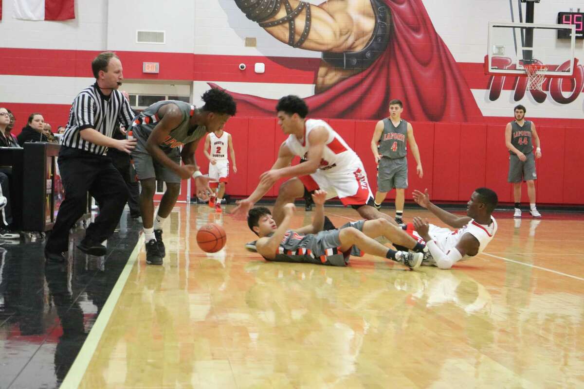 A loose ball in the fourth period has both South Houston and La Porte players on the floor, while a referee attempts to stay on top of the play.